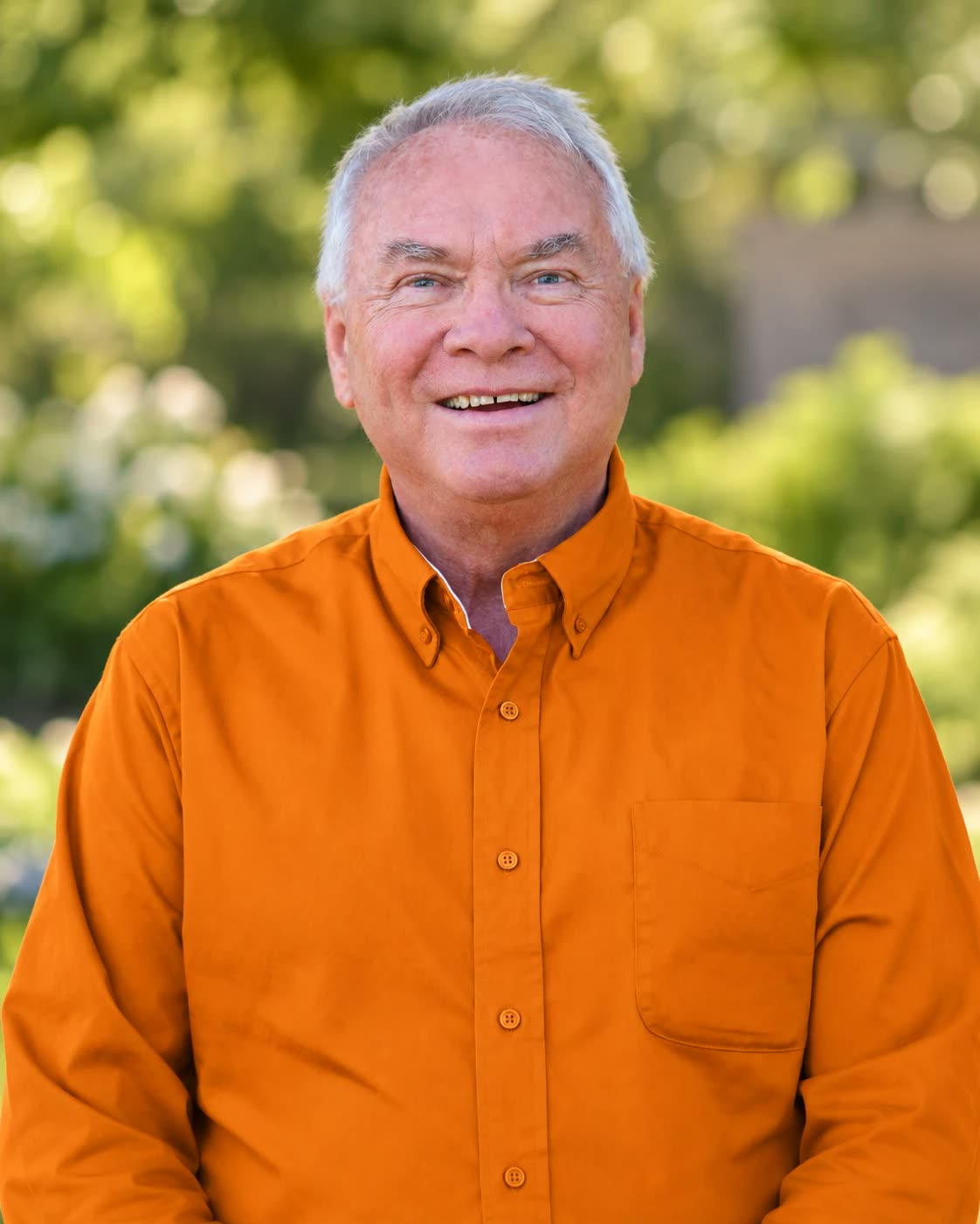 Reggie Johnson smiling outdoors in an orange shirt